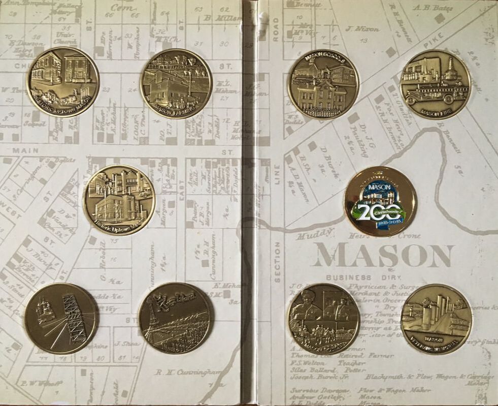Collectible coins placed inside booklet, featuring Mason historic landmarks